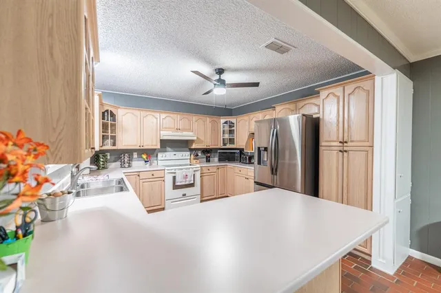 a kitchen with stainless steel appliances a refrigerator sink and cabinets