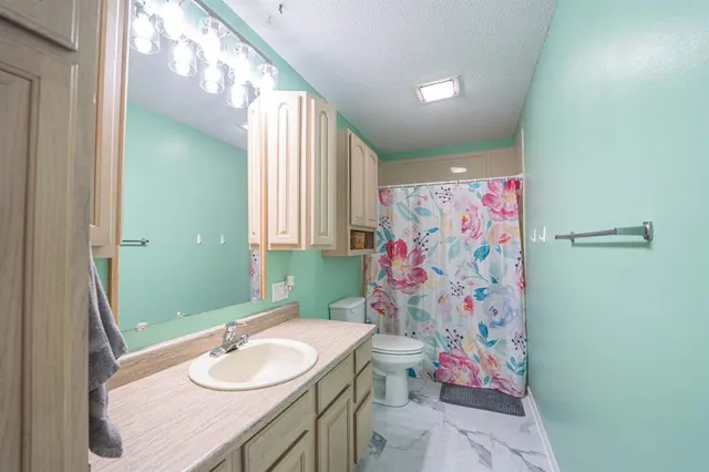 a bathroom with a sink vanity mirror and toilet