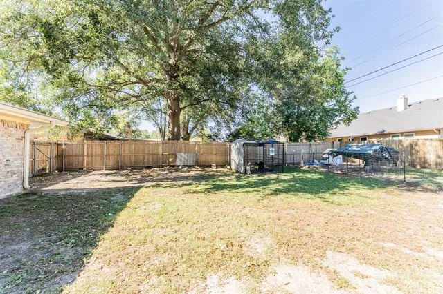 a view of a house with a yard and large tree