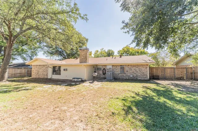 a view of an house with backyard and trees