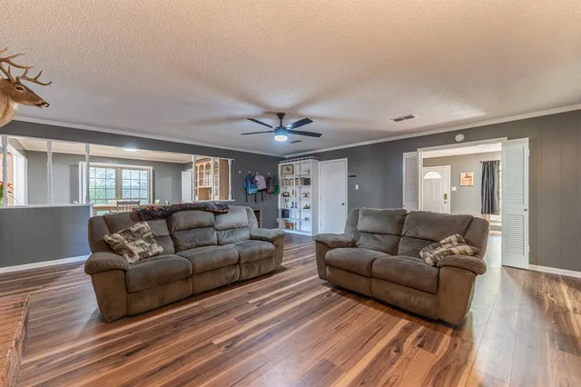 a living room with furniture and a wooden floor
