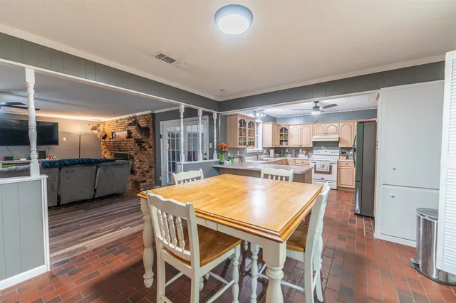 a kitchen with stainless steel appliances granite countertop a kitchen island a stove a table and chairs in it