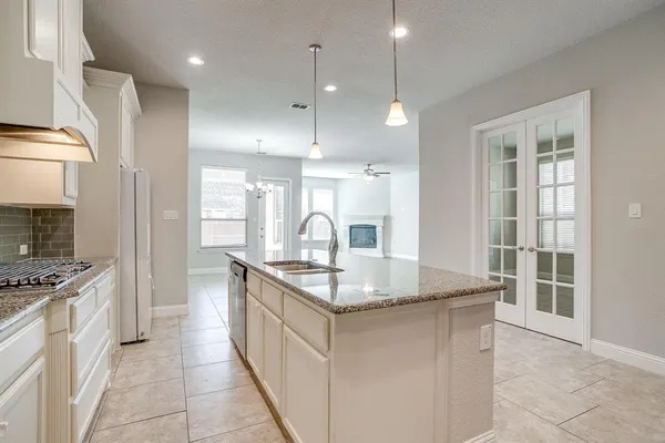 a kitchen with kitchen island granite countertop a sink stove and refrigerator