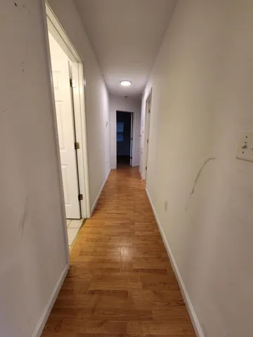 a view of a hallway with wooden floor