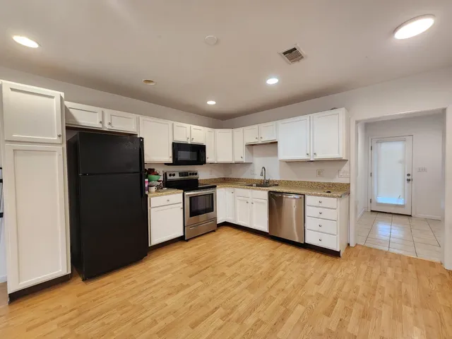 a kitchen with a refrigerator a sink and a stove top oven