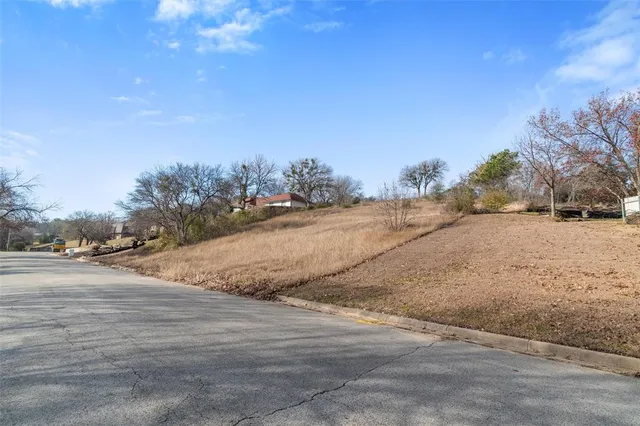 a view of dirt road with a building in the background