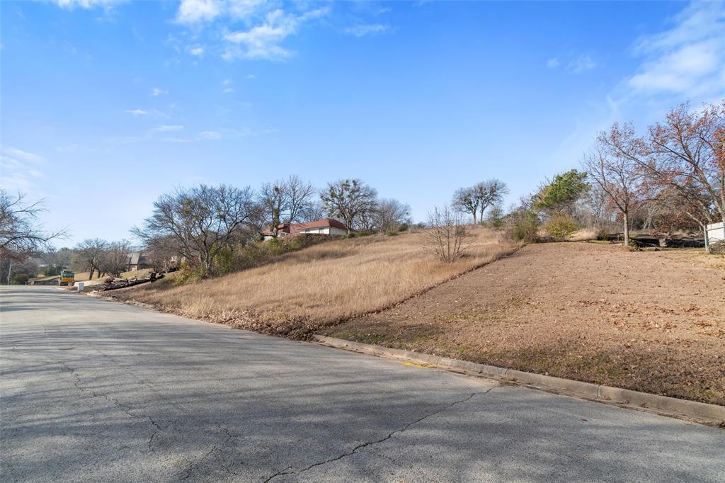 a view of dirt road with a building in the background