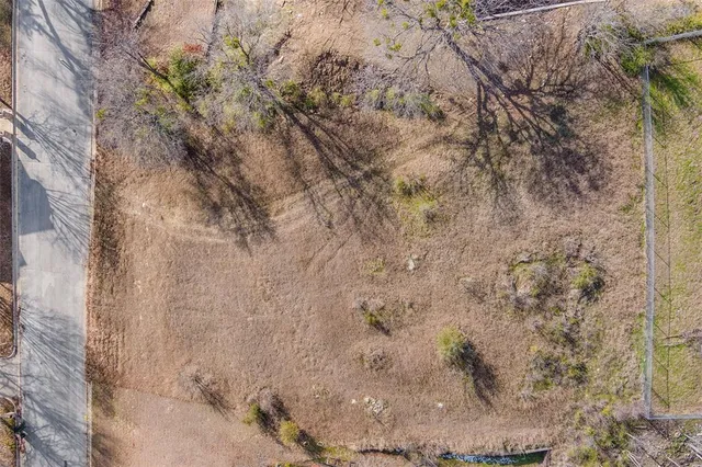 a view of a dry yard with wooden fence