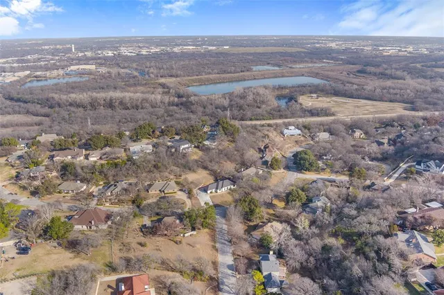 a view of dirt yard with large trees