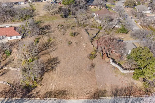 a view of a dry yard with wooden fence