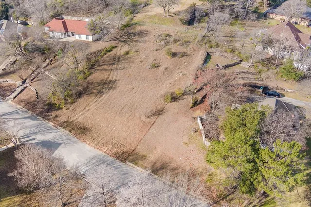 a view of a dry yard with lots of trees