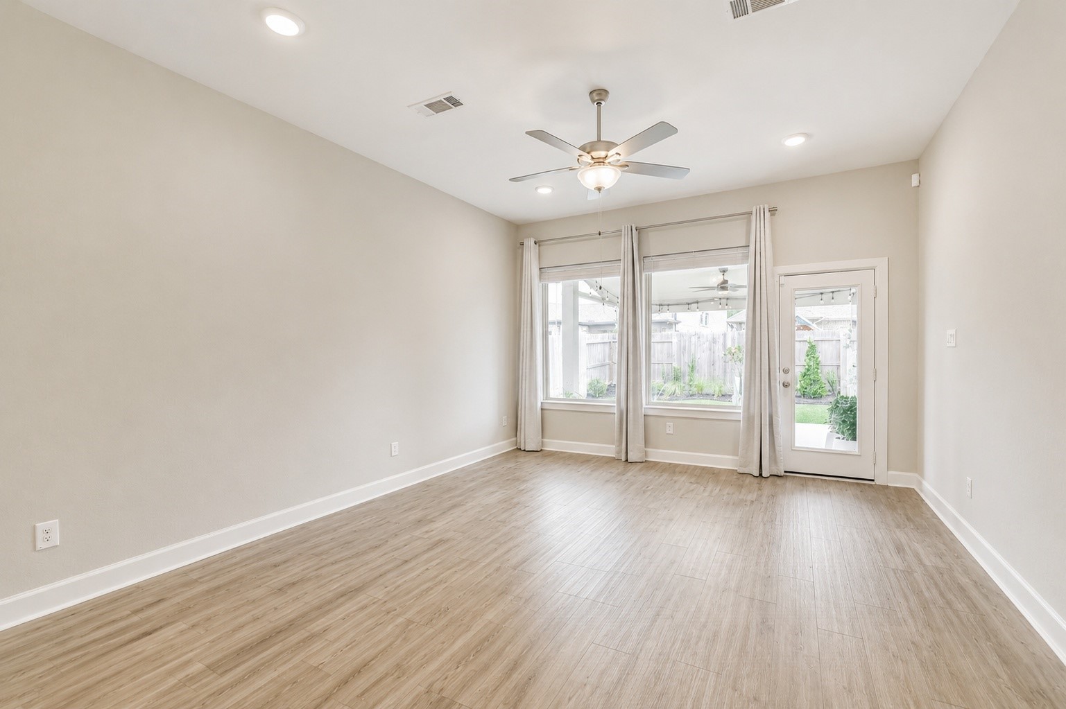 15611 Rising Wren Court Conroe, TX 77302 - Photo 17 of 38 an empty room with wooden floor and windows