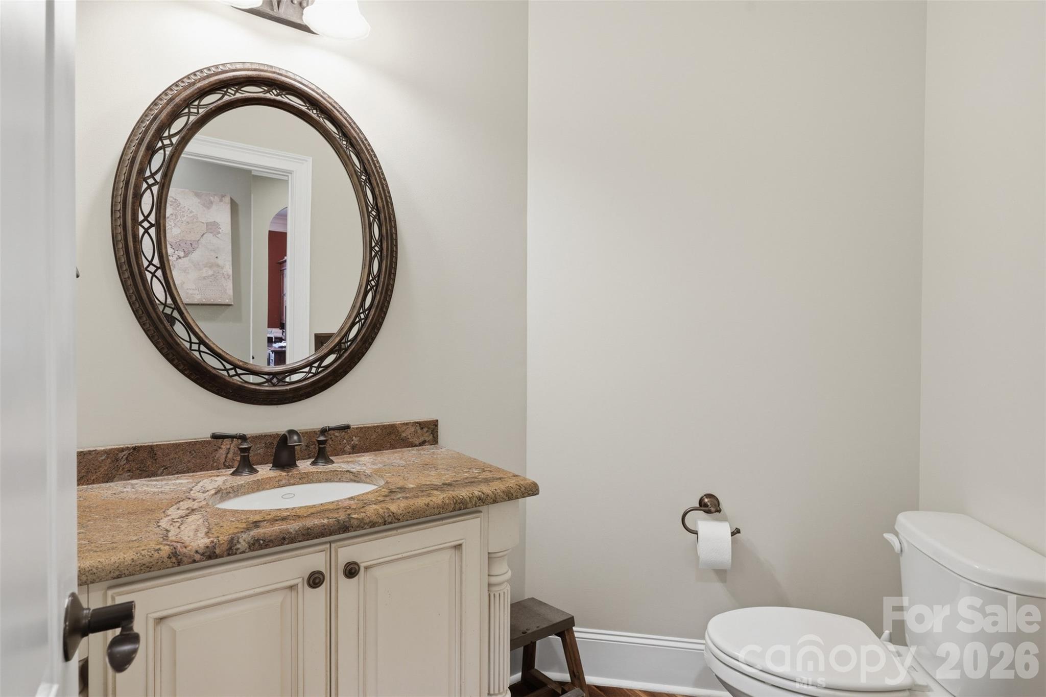 3638 Hogan Court Conover, NC 28613 - Photo 16 of 38 a bathroom with a granite countertop toilet a sink and a mirror