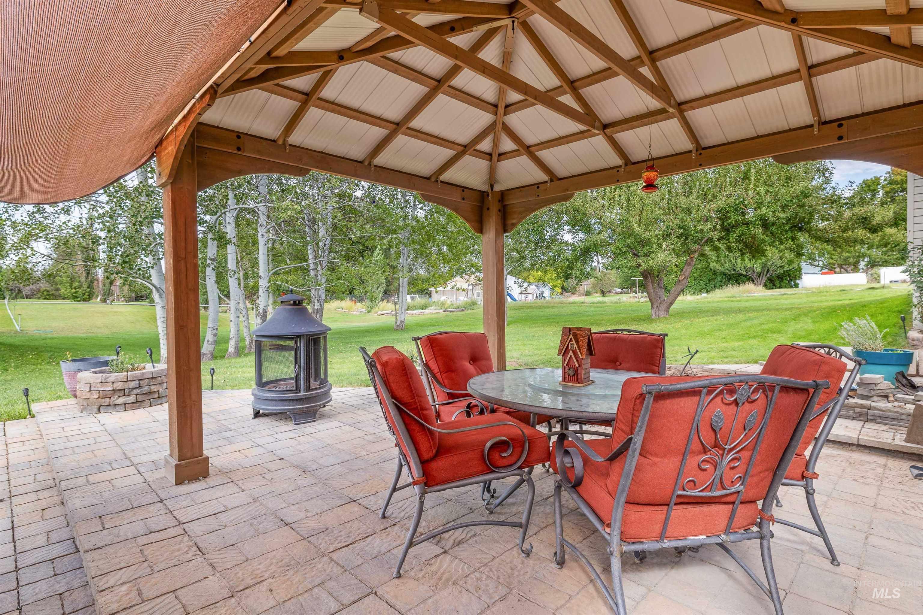 216 Ranch View Road West Jerome, ID 83338 - Photo 27 of 42 Expansive paver patio with a wooden gazebo featuring a white ceiling and retractable shade