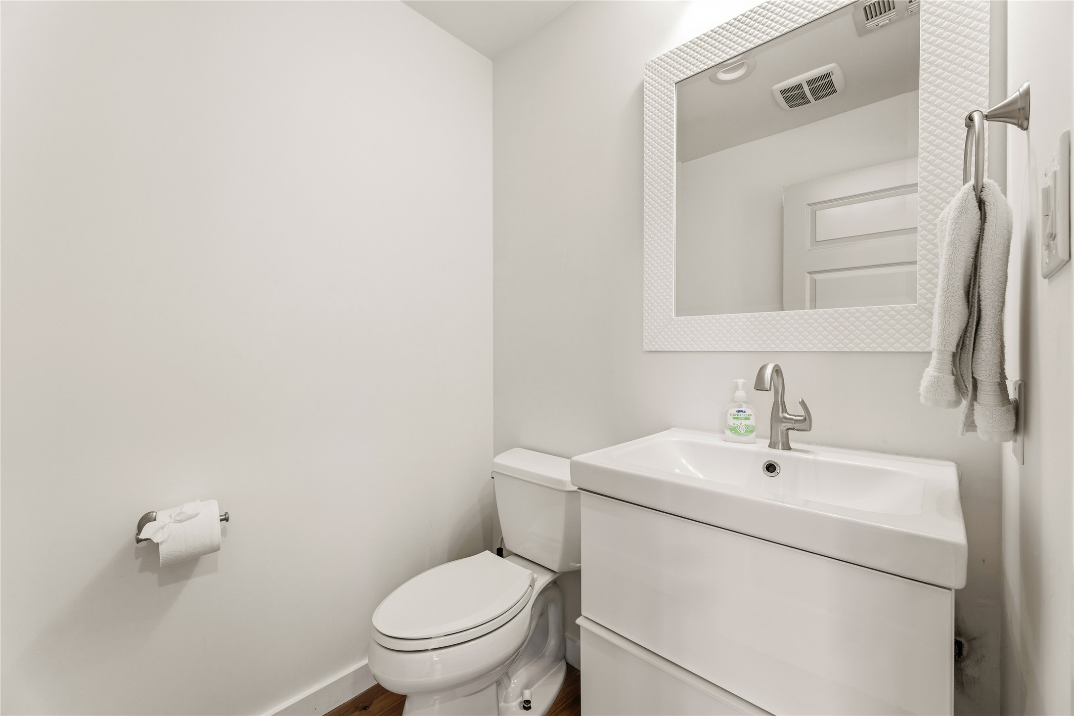 12901 Wire Road Leander, TX 78641 - Photo 10 of 40 An elegant powder room features a modern white vanity and warm wood flooring.