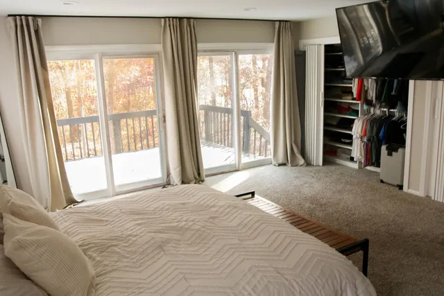 a bedroom with a bed and a large window