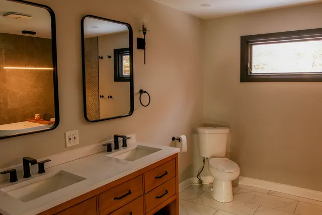 a bathroom with a toilet sink and mirror