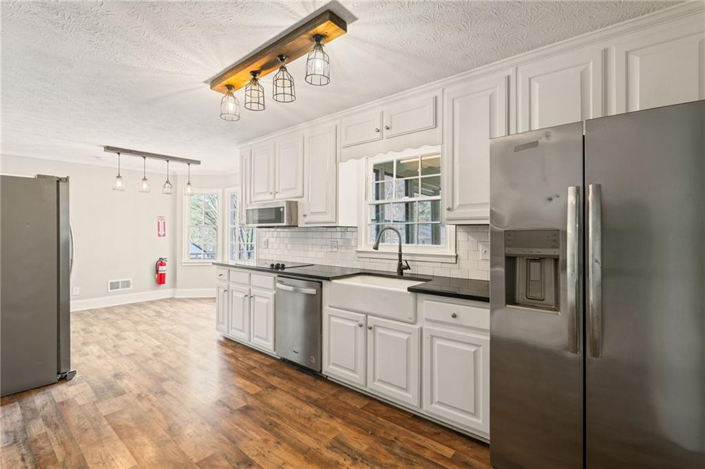 835 Lockriver Way Lawrenceville, GA 30044 - Photo 13 of 68 a kitchen with stainless steel appliances granite countertop a refrigerator a stove a sink and white cabinets