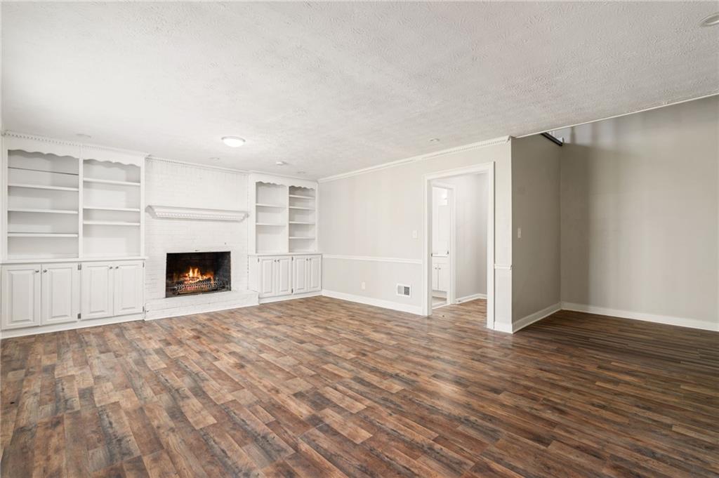 835 Lockriver Way Lawrenceville, GA 30044 - Photo 16 of 68 a view of an empty room with wooden floor fireplace and a window
