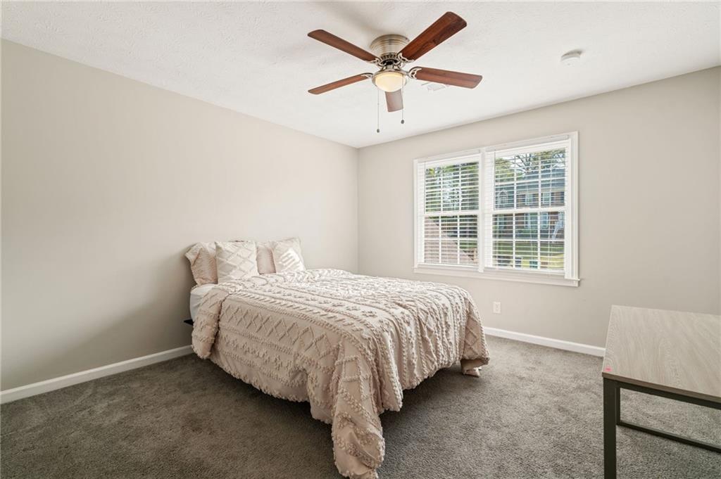 835 Lockriver Way Lawrenceville, GA 30044 - Photo 28 of 68 a bed sitting in a bedroom next to a window