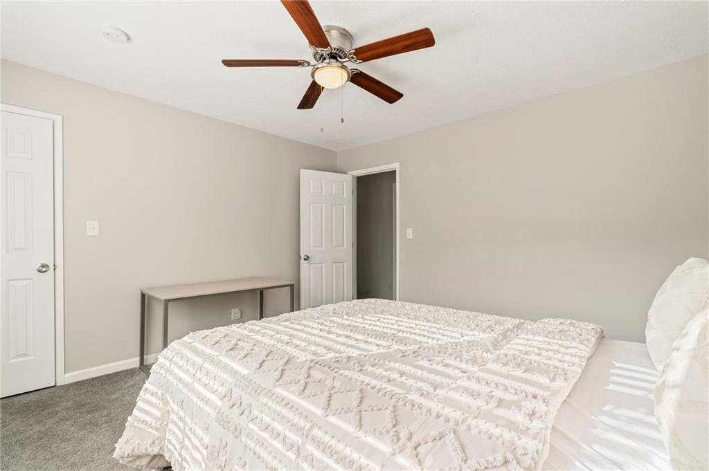 835 Lockriver Way Lawrenceville, GA 30044 - Photo 30 of 68 a bedroom with a bed and a ceiling fan