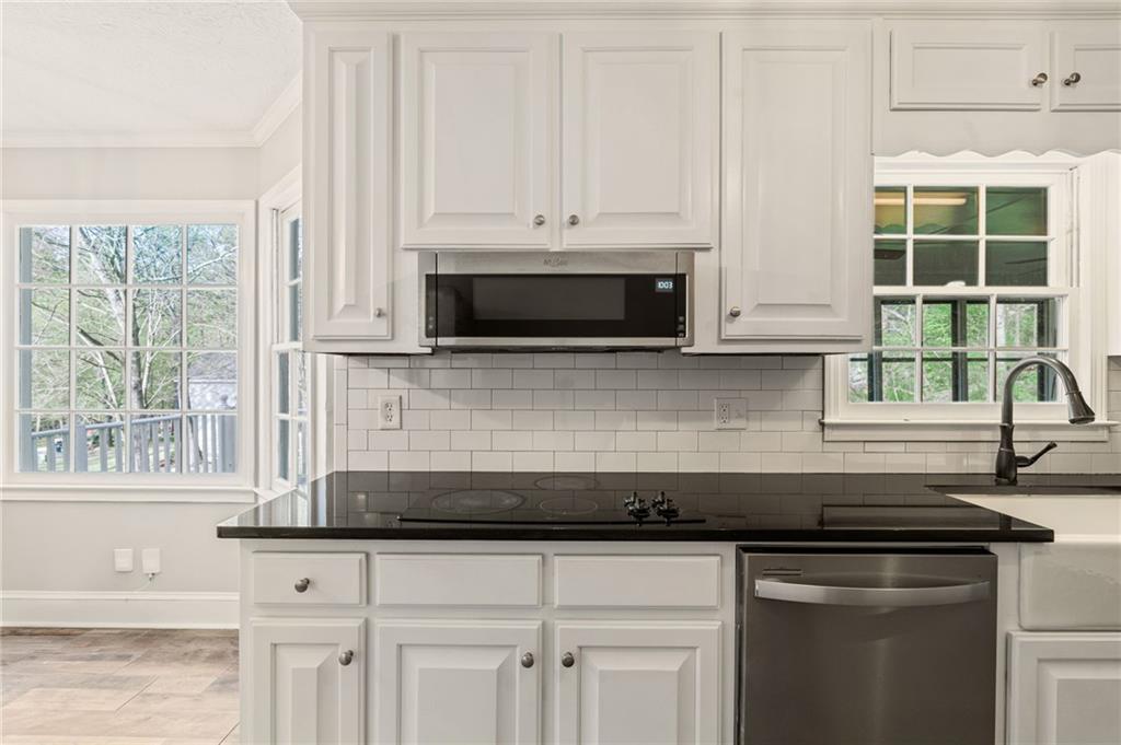 835 Lockriver Way Lawrenceville, GA 30044 - Photo 56 of 68 a kitchen with granite countertop a stove a sink and a microwave