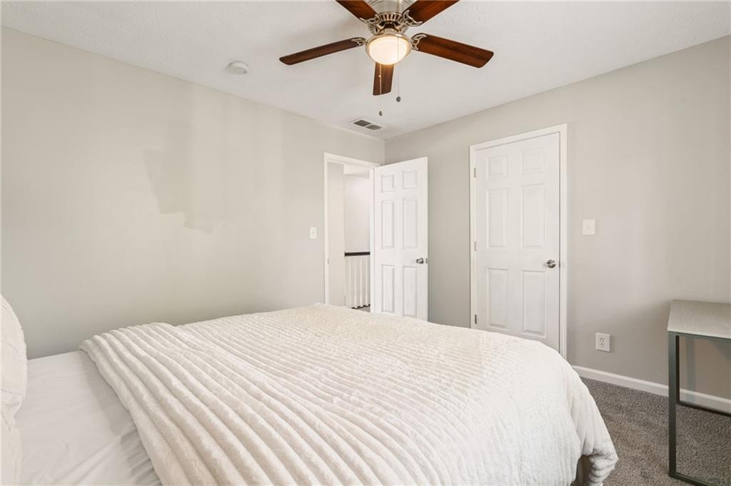 835 Lockriver Way Lawrenceville, GA 30044 - Photo 61 of 68 a bedroom with a large bed and a chandelier