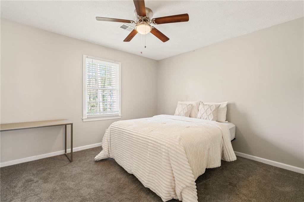 835 Lockriver Way Lawrenceville, GA 30044 - Photo 62 of 68 a bedroom with a bed and a ceiling fan