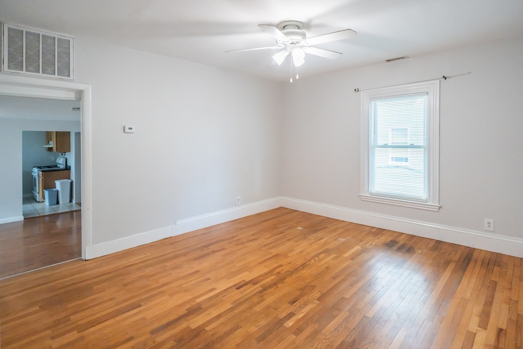 131 Summer Street, Unit 2 Somerville, MA 02143 - Photo 12 of 15 a view of empty room with wooden floor and fan