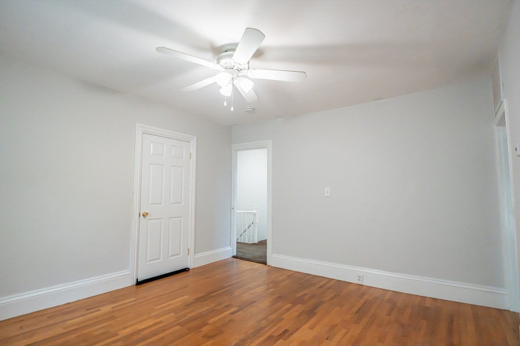 131 Summer Street, Unit 2 Somerville, MA 02143 - Photo 13 of 15 an empty room with wooden floor and fan window