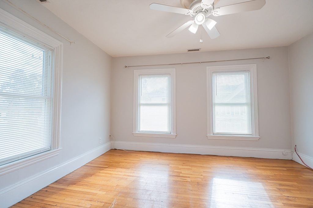 131 Summer Street, Unit 2 Somerville, MA 02143 - Photo 4 of 15 a view of an empty room with wooden floor and window