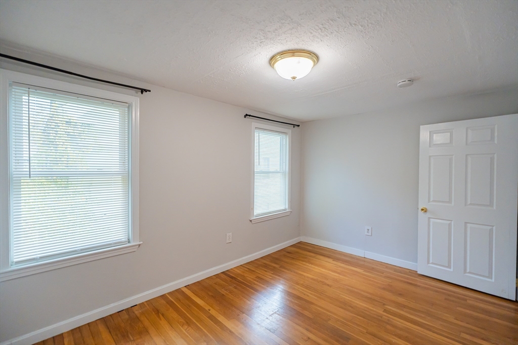 131 Summer Street, Unit 2 Somerville, MA 02143 - Photo 7 of 15 an empty room with wooden floor and windows