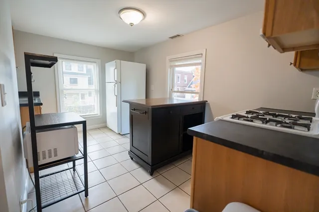 a kitchen with stainless steel appliances granite countertop a stove refrigerator and a more cabinets