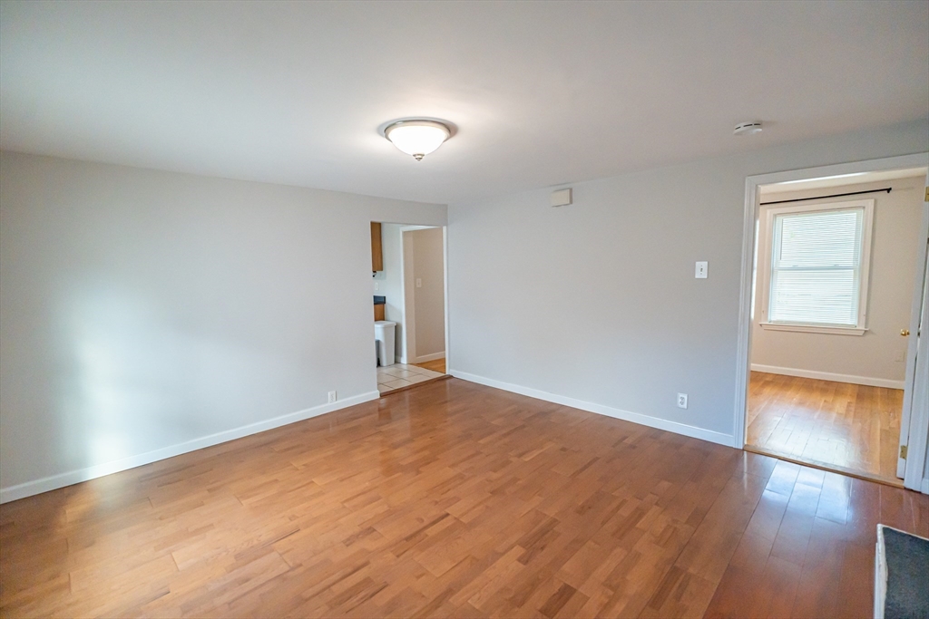 131 Summer Street, Unit 2 Somerville, MA 02143 - Photo 10 of 15 an empty room with wooden floor & door