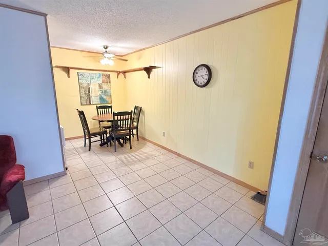 a view of an empty room with wooden floor and chair