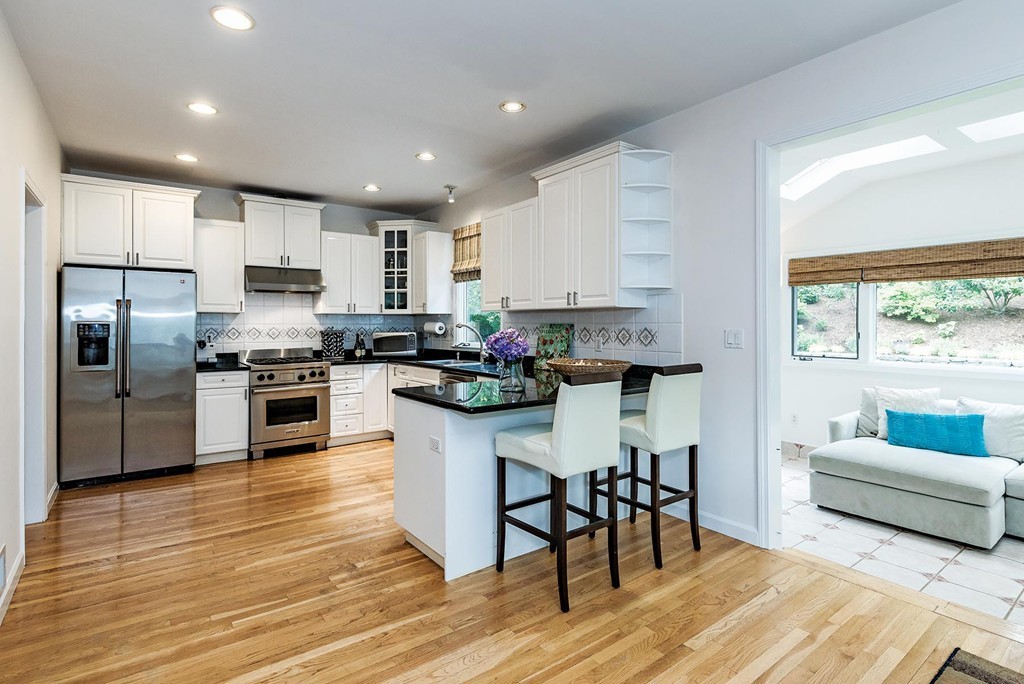 200 Country Club Road Newton, MA 02459 - Photo 4 of 12 a kitchen with stainless steel appliances granite countertop a refrigerator a stove top oven a sink dishwasher and white cabinets with wooden floor