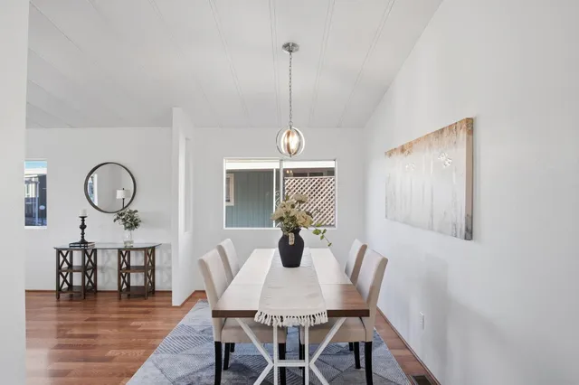 a dining room with furniture a chandelier and wooden floor