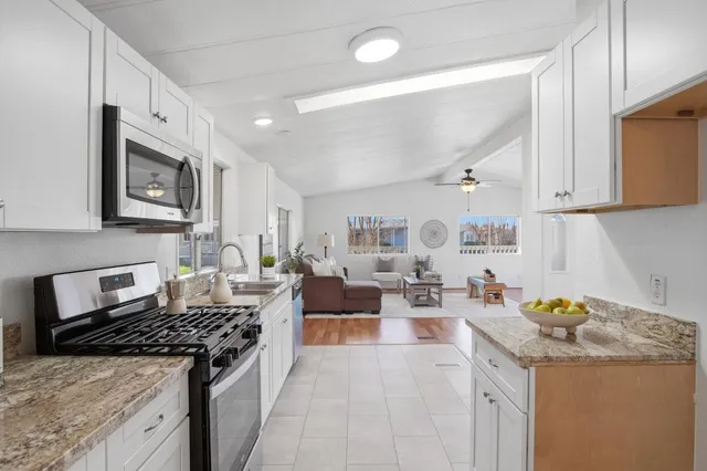 a kitchen with a stove a sink a refrigerator and cabinets