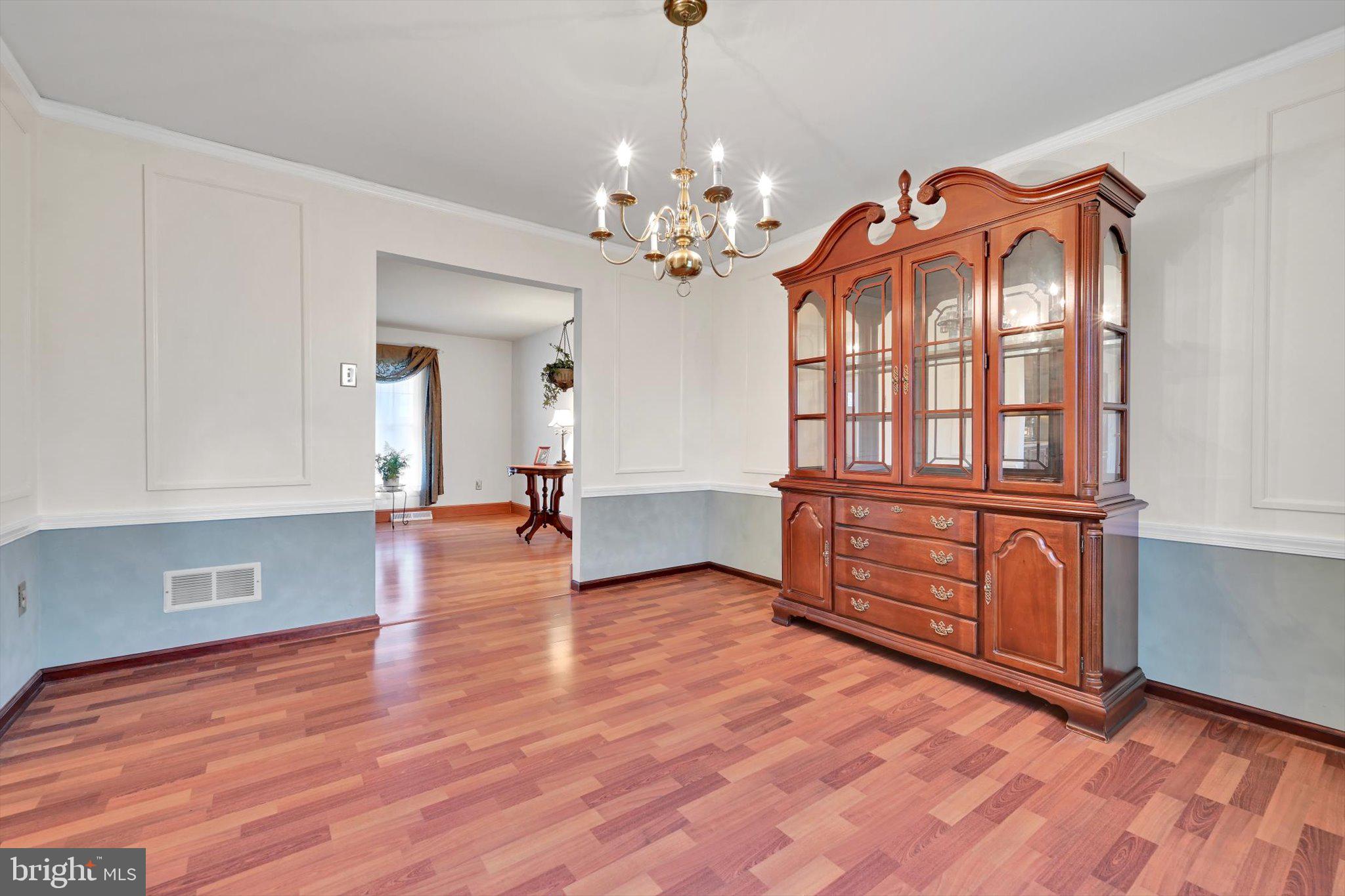 1546 Singer Road Wyomissing, PA 19610 - Photo 11 of 40 a view of an empty room with chandelier and wooden floor