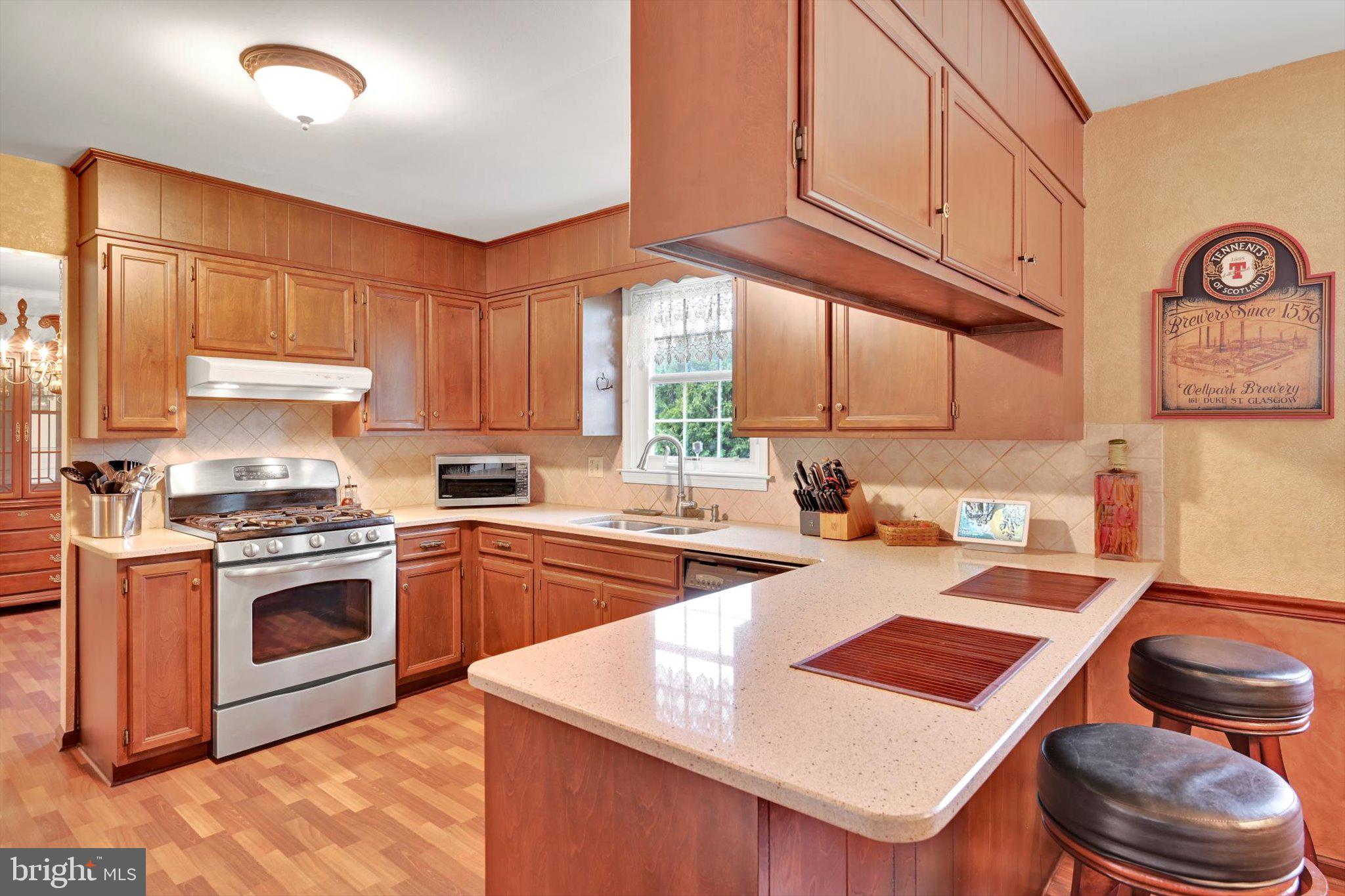 1546 Singer Road Wyomissing, PA 19610 - Photo 5 of 40 a kitchen with a stove a sink dishwasher and a refrigerator with wooden floor