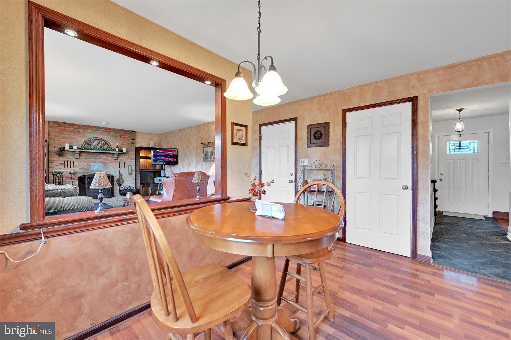 1546 Singer Road Wyomissing, PA 19610 - Photo 9 of 40 a dining room with wooden floor a chandelier a wooden table and chairs