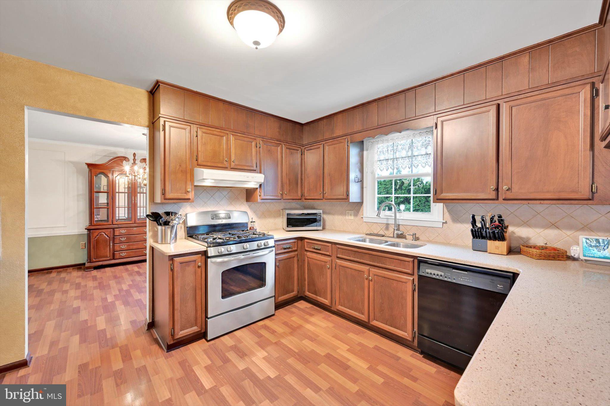 1546 Singer Road Wyomissing, PA 19610 - Photo 10 of 40 a kitchen with stainless steel appliances granite countertop wooden cabinets a sink a stove a refrigerator and island with wooden floor