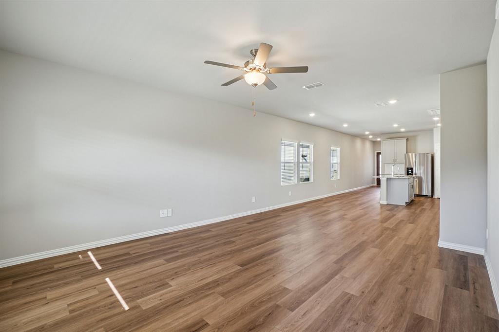 822 Sunflower Road Lavon, TX 75166 - Photo 13 of 38 a view of an empty room with wooden floor and a ceiling fan