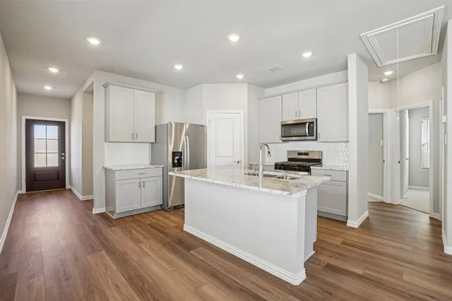 a kitchen with white cabinets and stainless steel appliances