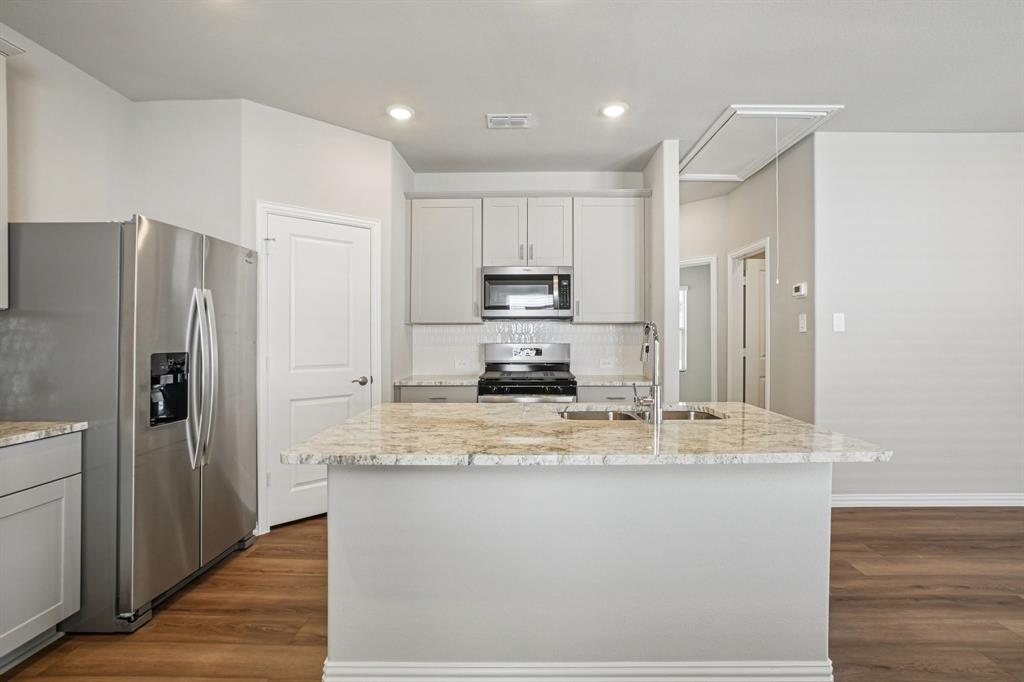 822 Sunflower Road Lavon, TX 75166 - Photo 15 of 38 a kitchen with kitchen island a counter top space cabinets and stainless steel appliances