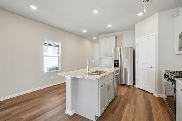 a kitchen with stainless steel appliances granite countertop a stove and a refrigerator