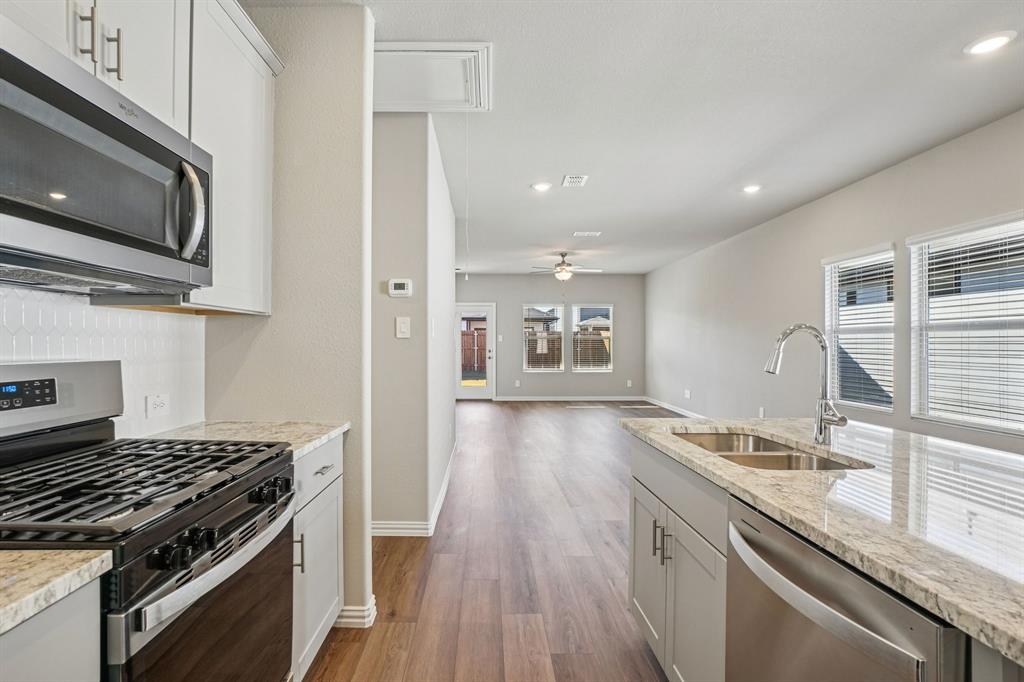 822 Sunflower Road Lavon, TX 75166 - Photo 18 of 38 a kitchen with granite countertop a stove and a sink