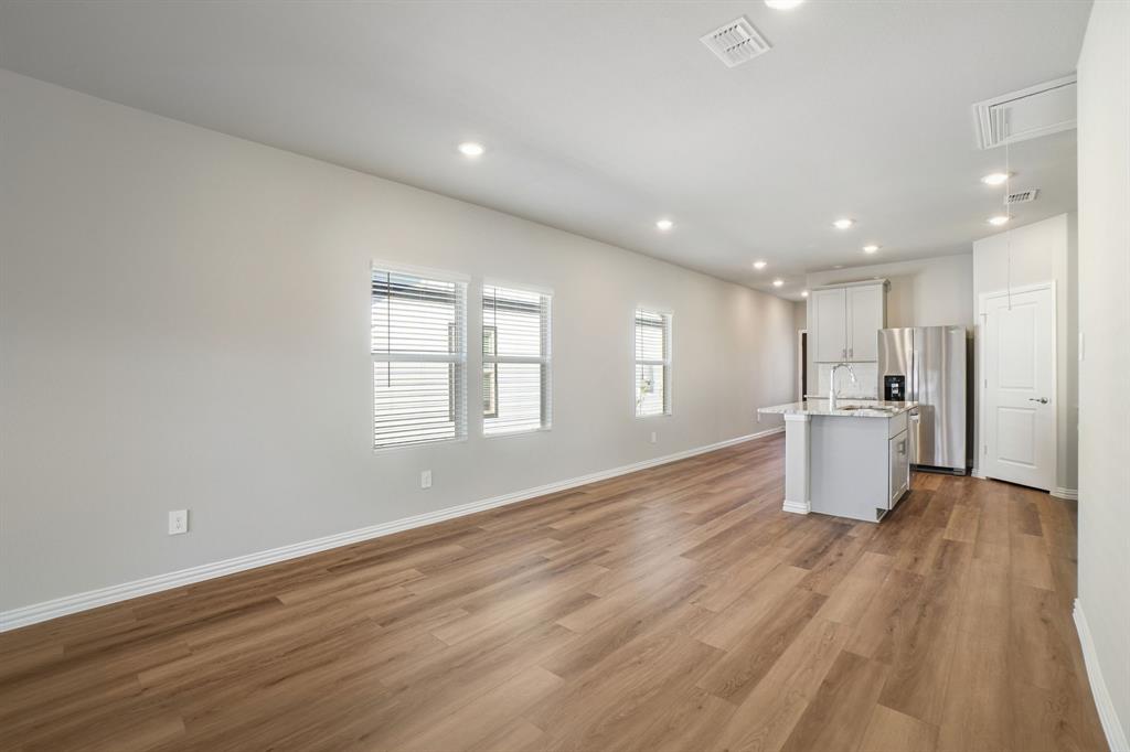 822 Sunflower Road Lavon, TX 75166 - Photo 6 of 38 a view of an empty room with wooden floor and a window
