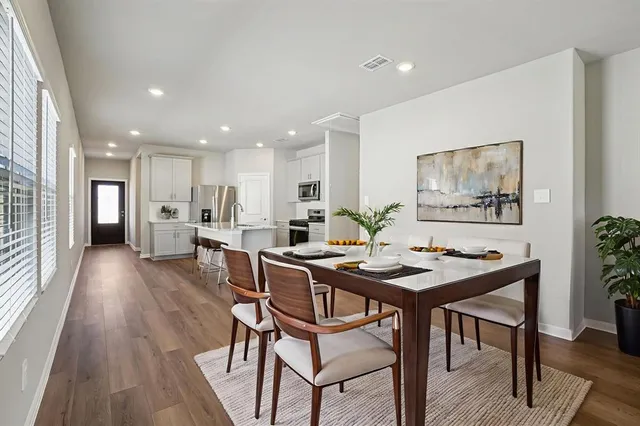 a view of a dining room with furniture wooden floor and kitchen
