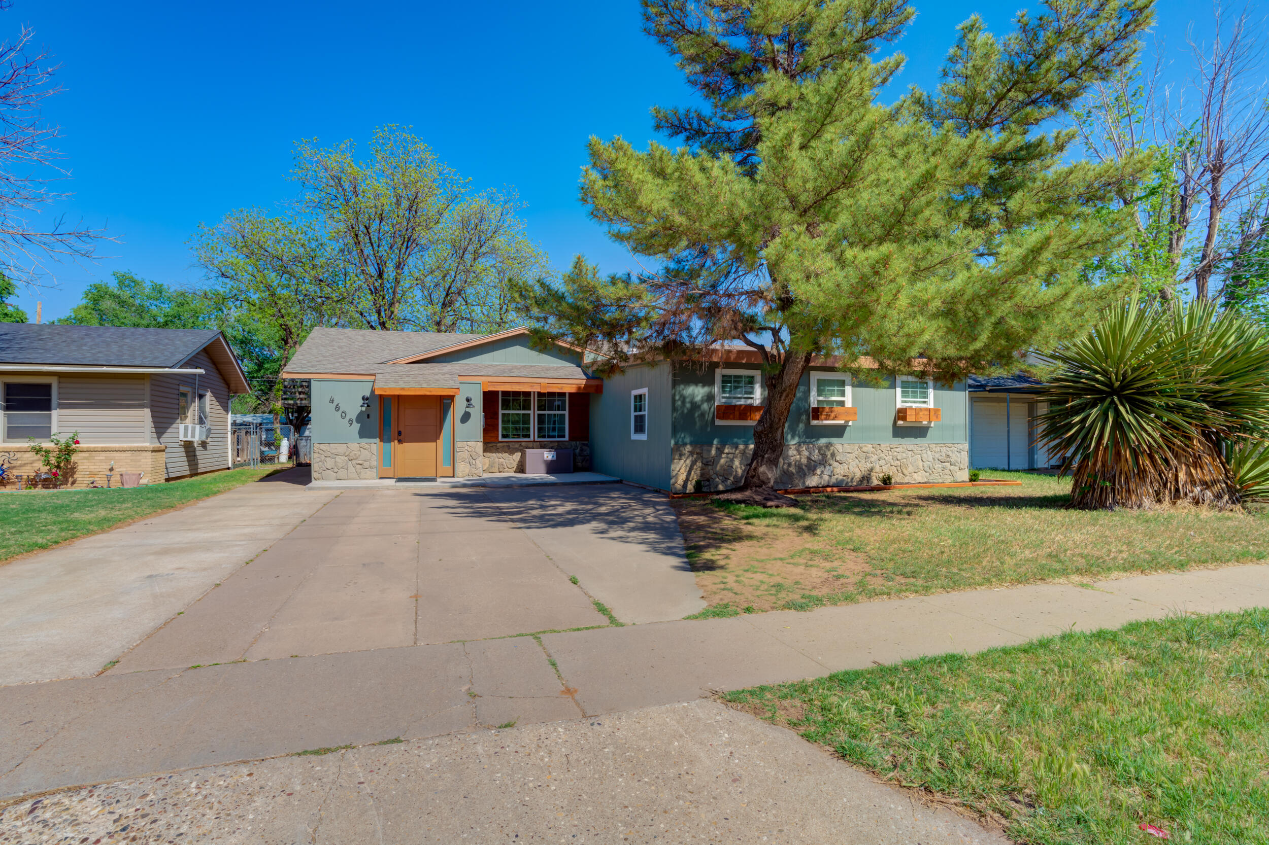4609 Elgin Avenue Lubbock, TX 79413 - Photo 1 of 46 a front view of a house with a yard and potted plants